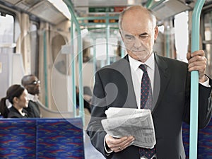 Businessman Reading Newspaper In Train