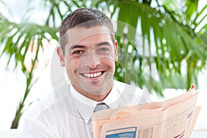 Businessman reading a newspaper in workplace