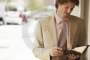 Businessman Reading Notes In Organizer
