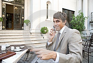 Businessman reading paper in cafe.