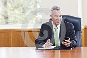Businessman reading text messages on his phone photo