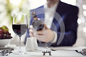 Businessman reading a wine bottle label in restaurant