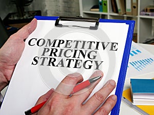 Businessman reads competitive pricing strategy report.