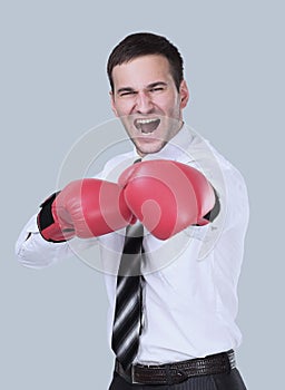 Businessman ready to fight with boxing gloves over gray