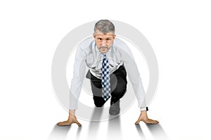 Businessman in ready to run position isolated over white background