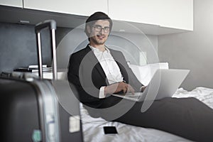 Businessman ready to travel works with his laptop