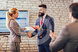 Businessman receiving award from businesswoman