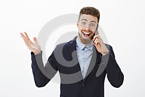 Businessman receiving excellent news. Happy and excited delighted good-looking male entrepreneur in elegant suit holding