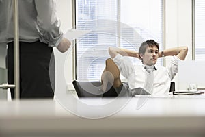 Businessman Reclining On Chair And Ignoring Boss photo