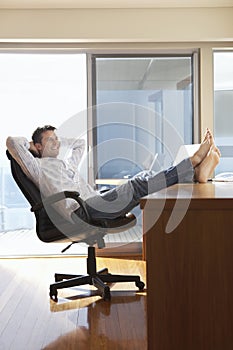 Businessman Reclining With Feet Up On Desk