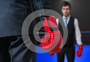 Businessman with red boxing gloves is boxing in ring with his boss