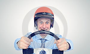 Businessman in a red helmet with steering wheel