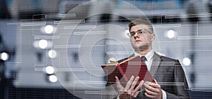 Businessman with a reference book in his hands looking at the production plan