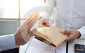 Businessman refusing to receive the money in a brown envelope to sign a business contract