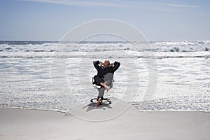 Businessman Relaxing On Chair At Beach photo