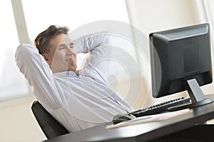 Businessman Relaxing While Looking At Desktop Pc