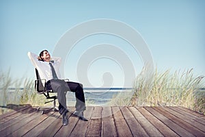 Businessman Relaxing on Office Chair at Beach