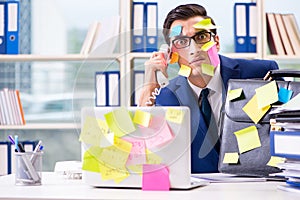 The businessman with reminder notes in multitasking concept