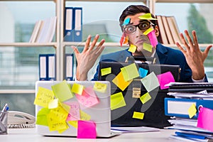 The businessman with reminder notes in multitasking concept