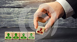 The businessman removes / dismisses the employee from the team. management within the team. wooden blocks with a picture of worker
