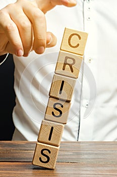 Businessman removes wooden blocks with the word Crisis. The exit from the crisis and financial stability. Focus on resolving the