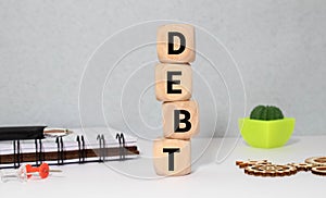Businessman removes wooden blocks with the word Debt. Reduction or restructuring of debt. Bankruptcy announcement