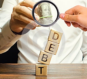 Businessman removes wooden blocks with the word Debt. Debt relief or cancellation is the partial or total forgiveness of debts, or photo