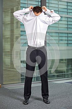 Businessman removing shirt at office