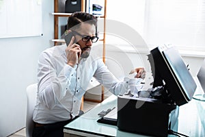 Businessman Removing Stuck Paper In The Printer