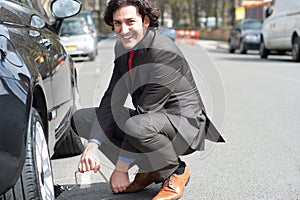 Businessman repairing car roadside