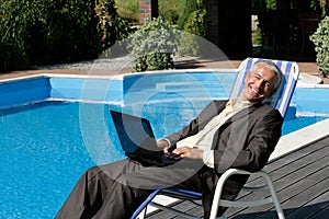 Businessman resting on deck chair