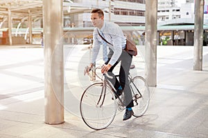 Businessman riding bicycle to work on urban street in morning .transport and healthy