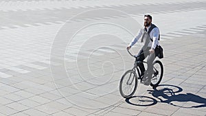 Businessman riding bicycle to workplace for protecting environment