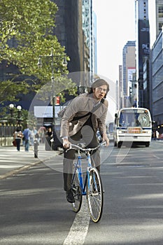 Businessman Riding Bicycle On Urban Street