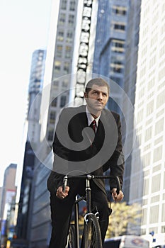 Businessman Riding Bicycle On Urban Street