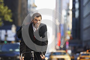 Businessman Riding Bicycle On Urban Street