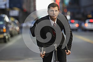 Businessman Riding Bicycle On Urban Street