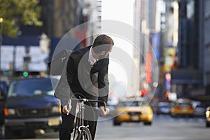 Businessman Riding Bicycle On Urban Street