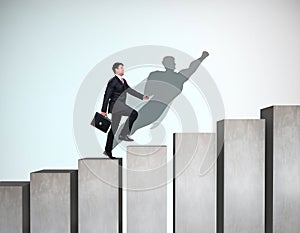 Businessman rise up on the career ladder with superhero shadow on the wall.