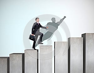 Businessman rise up on the career ladder with superhero shadow on the wall.