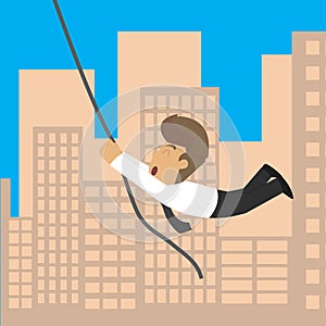 Businessman a rope across the building, the risk and excitement