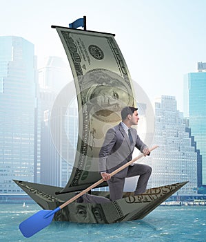 The businessman rowing on dollar boat in business financial conc