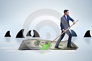 The businessman rowing on dollar boat in business financial concept
