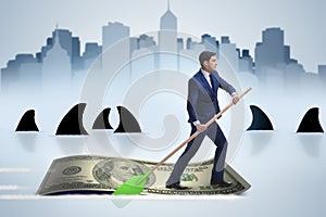 The businessman rowing on dollar boat in business financial concept