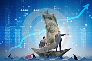 The businessman rowing on dollar boat in business financial concept