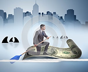 Businessman rowing on dollar boat in business financial concept