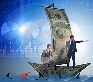 Businessman rowing on dollar boat in business financial concept