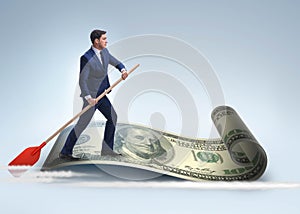 Businessman rowing on dollar boat in business financial concept