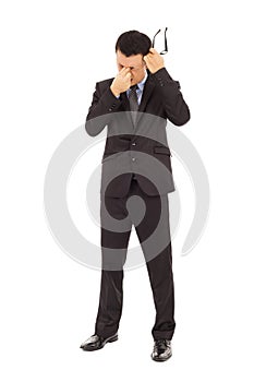 Businessman rubbing his eyes and holding glasses