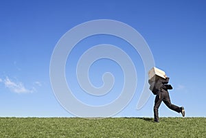 Businessman running with box